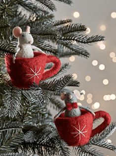 two felt mice are sitting in mugs on a christmas tree