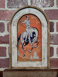 an image of a man riding a horse on the side of a building with brick walls