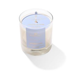 a candle that is sitting on a white surface with a blue label in front of it