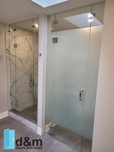 a walk in shower sitting next to a white wall and tiled floor with glass doors