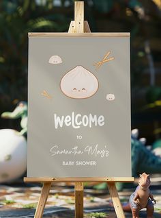 a welcome sign for someone to be born in the baby's shower is displayed on an easel