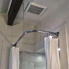 a bathroom with a shower, toilet and bathtub next to a ceiling mounted air conditioner