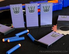 some blue and purple items are on a black table with orange pencils next to them