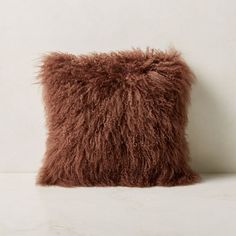 a brown furry pillow sitting on top of a white counter