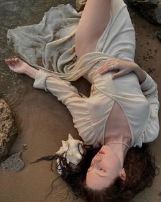 a woman is laying on the beach with her legs spread out