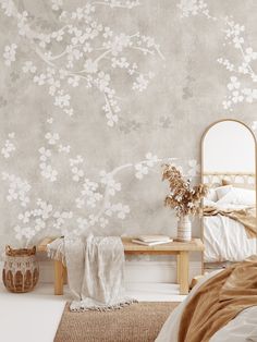 a bedroom with a bed, mirror and flowers on the wall