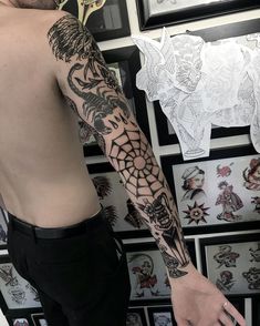 a man with a dragon tattoo on his arm next to some other tattoos and stickers