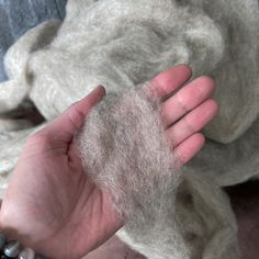 a hand is holding something that looks like wool