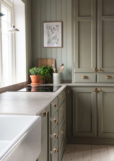 a kitchen with green cabinets and white counter tops