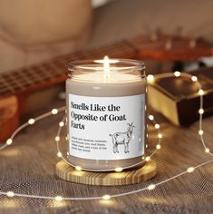 a candle sitting on top of a table next to a string of lights and a guitar