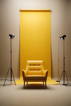 a yellow chair sitting in front of two spotlights