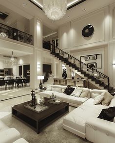 a living room filled with lots of furniture and a chandelier hanging from the ceiling