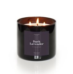 a black candle with three candles in it and the words dark lavender written on it