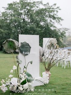 an arrangement of flowers and greenery on display in the grass at a wedding ceremony