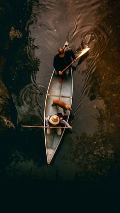 two people in a canoe paddling on the water with paddles and oars