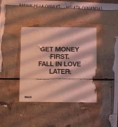 a sign on the side of a building that says get money first fall in love later