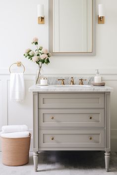 a bathroom vanity with marble top and gold accents