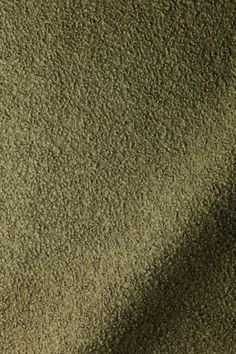 the shadow of an umbrella on top of a carpeted area with green and brown colors