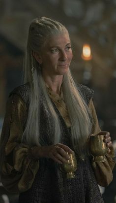 game of thrones character daeneria starke holding two golden cups in her hands