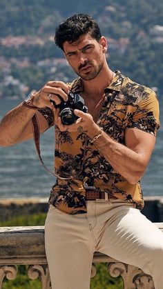 a man sitting on a bench holding a camera