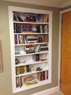 a bookshelf in the corner of a room next to a door with pictures on it