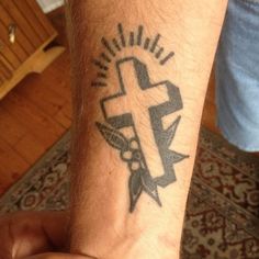 a man with a cross tattoo on his arm