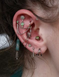 a close up of a person with ear piercings on their ears and behind the ear