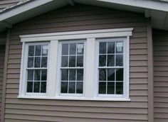 a brown house with two windows on the side and one window in the back ground