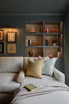 a white couch sitting in front of a book shelf filled with books