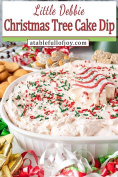 a christmas tree cake dip in a white bowl with candy canes and pretzels around it