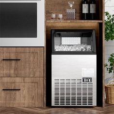 an ice machine sitting on top of a wooden counter next to a microwave and oven