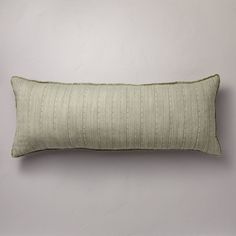 a green striped pillow sitting on top of a white wall