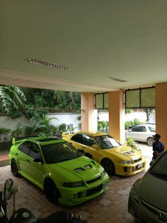 three cars are parked in a garage next to each other