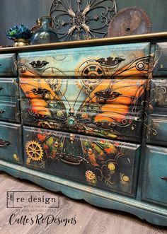 an old dresser painted with steampunk and gears on the drawers is shown in this image