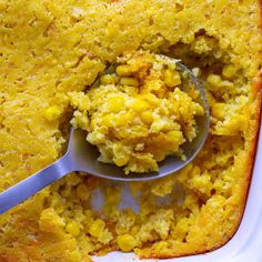 corn casserole in a white dish with a spoon