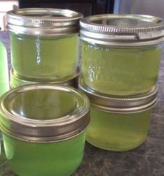 three jars filled with green liquid sitting on top of a counter