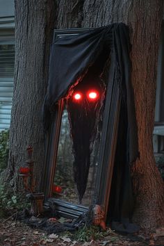 a creepy looking mirror sitting under a tree