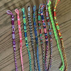 five different colored lanyards are lined up on a table with one knot in the middle