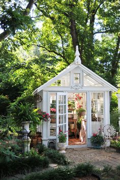 a small white house with lots of potted plants