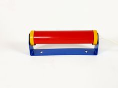 a red, yellow and blue plastic object on a white surface with a cord attached to it