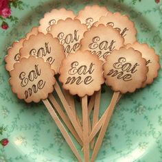 six cookies with words on them are sitting on a green and blue plate in the shape of flowers