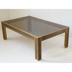 a glass and wood coffee table sitting on top of a white floor