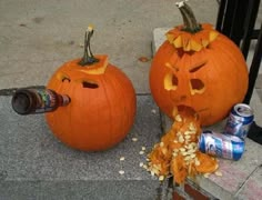 two pumpkins with faces carved into them sitting on the sidewalk next to cans of beer