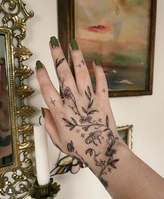 a woman's hand with flowers and stars tattooed on the middle of her palm