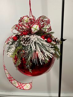 a christmas ornament hanging from a pole with red and white decorations on it