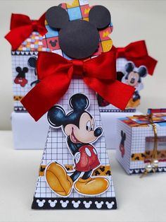 two boxes with mickey mouse designs on them and a bow tied around the top one