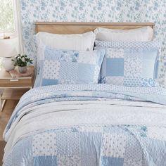 a blue and white quilted bed with pillows