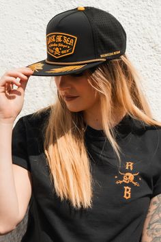 a woman wearing a black hat with gold lettering on the brim and side view