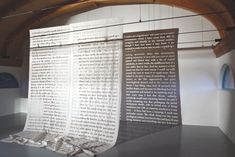 a large piece of paper sitting on top of a table next to a wall covered in words