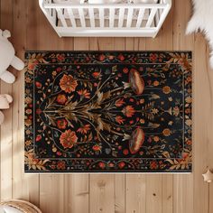 a black rug with flowers and leaves on it in the middle of a wooden floor